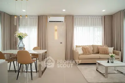 Modern living room with elegant decor, featuring a cozy sofa and stylish dining area.