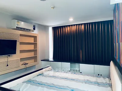 Modern bedroom with built-in shelves and air conditioning, featuring stylish curtains and a comfortable bed.