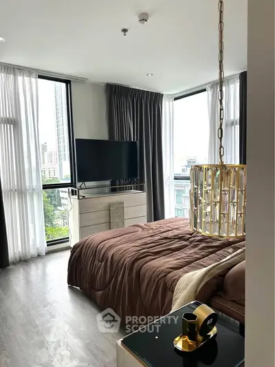 Luxurious bedroom with modern decor and city view, featuring elegant lighting and large windows.