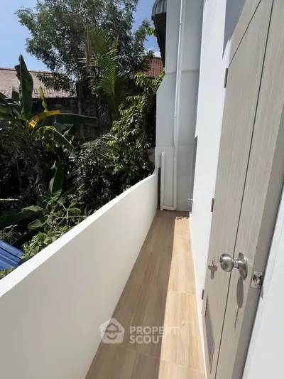 Charming narrow balcony with wooden flooring and lush garden view