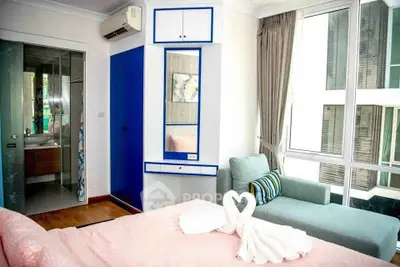 Charming bedroom with large windows and cozy seating area in modern apartment