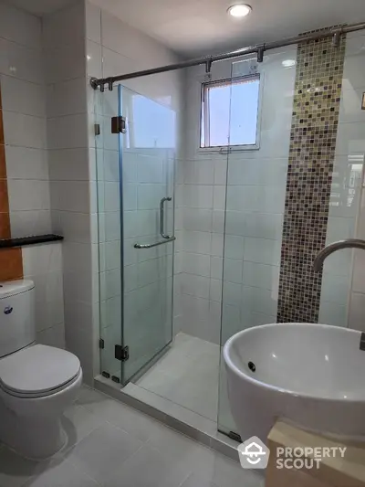 Modern bathroom with glass shower enclosure and stylish fixtures