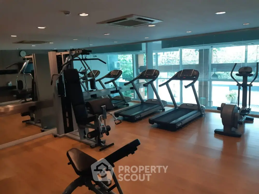 Modern gym with state-of-the-art fitness equipment and large windows for natural light.