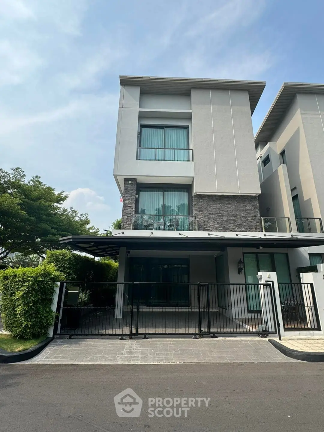 Modern three-story townhouse with sleek design and large windows in a serene neighborhood.