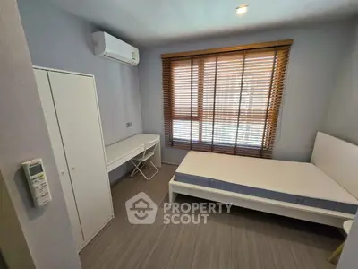Modern bedroom with minimalist design, featuring a bed, desk, and air conditioning unit, perfect for comfort and style.