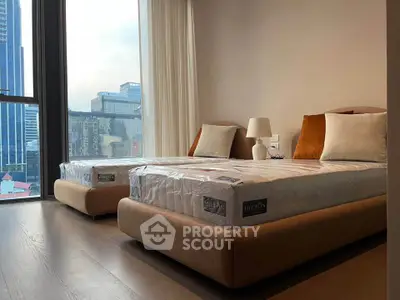 Modern bedroom with twin beds and city view, perfect for urban living.