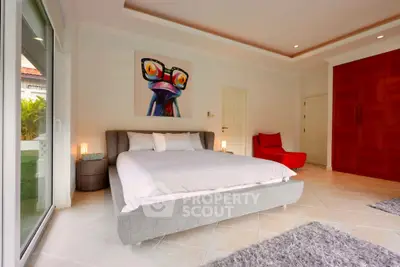 Spacious bedroom with modern decor and large windows for natural light.