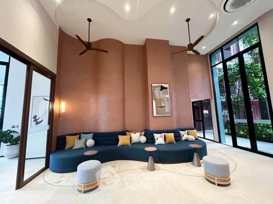 Luxurious modern living room with high ceilings, stylish furniture, and large windows offering garden views.