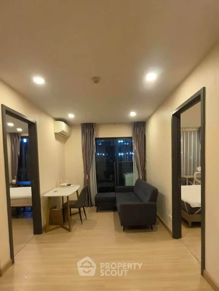 Modern living room with sleek furniture and balcony view in a stylish apartment.