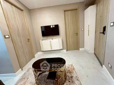 Modern living room with sleek TV setup and stylish coffee table in a cozy apartment.