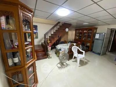 Cozy living area with wooden staircase and display cabinets