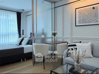 Modern studio apartment with stylish decor, featuring a cozy living area and elegant bedroom separated by glass partition.