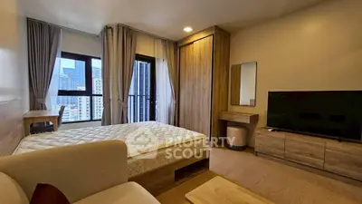 Modern bedroom with city view, featuring a cozy bed, stylish furniture, and large windows for natural light.
