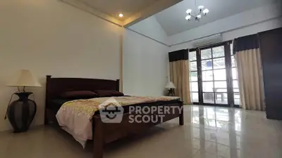 Spacious bedroom with elegant decor and large windows for natural light