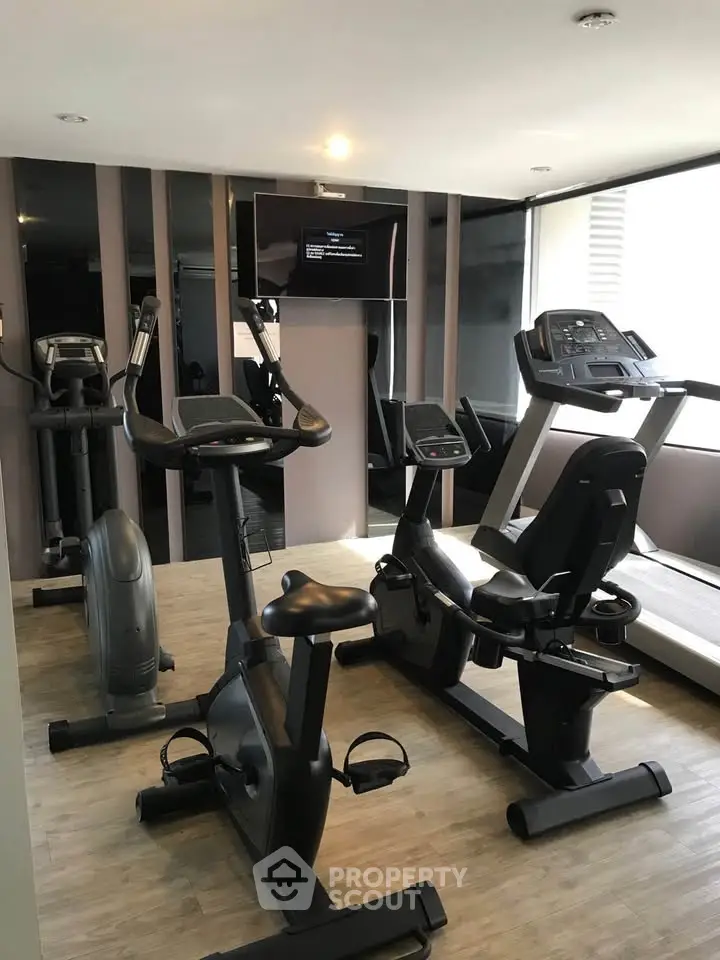 Modern gym with state-of-the-art exercise equipment in luxury apartment building.