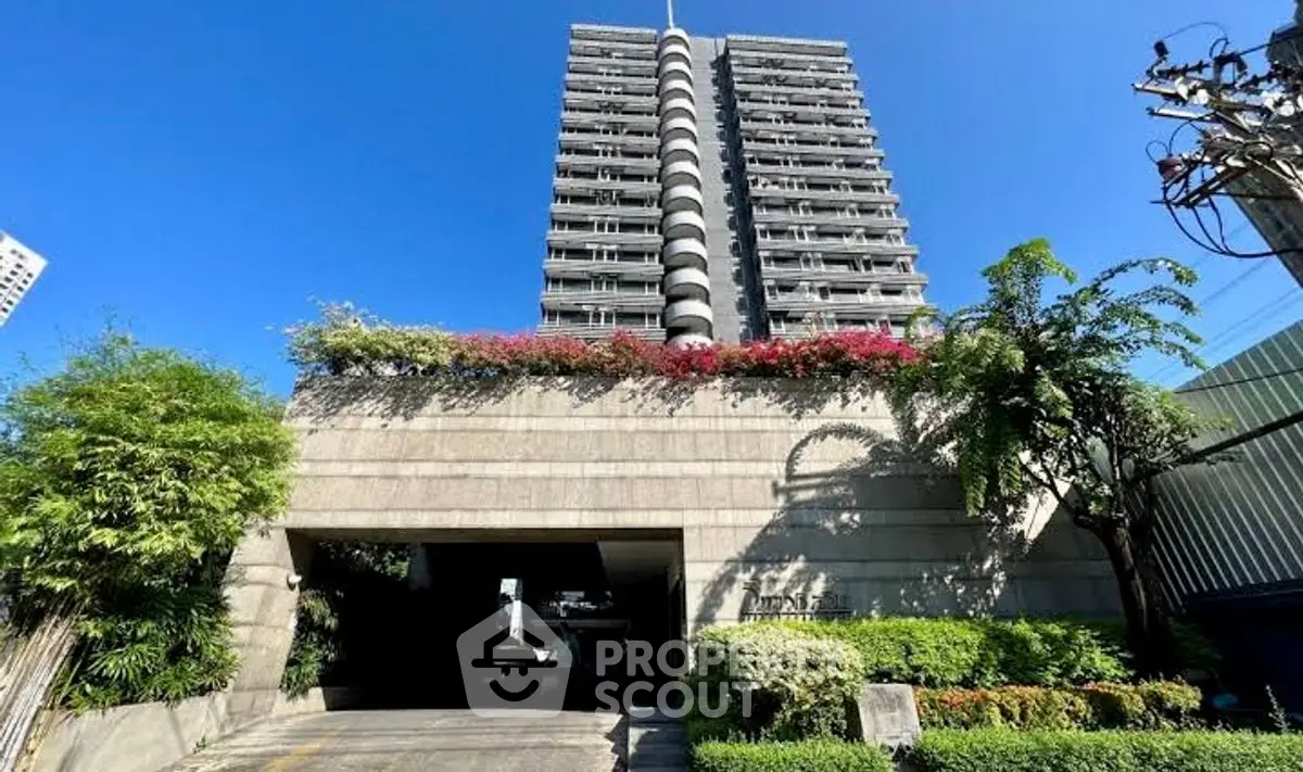 Stunning high-rise building with lush greenery and vibrant flowers, perfect urban living.