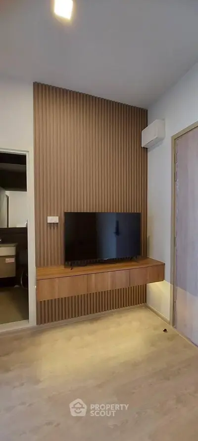 Modern living room with sleek TV setup and wooden panel accent wall