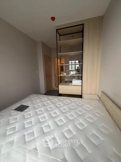 Modern bedroom with stylish shelving and comfortable mattress in a cozy apartment.