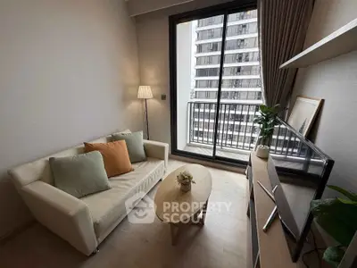 Modern living room with cozy sofa, stylish decor, and balcony view in urban apartment.