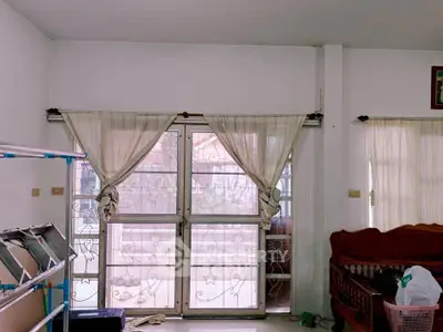 Spacious living room with large windows and natural light, perfect for cozy family gatherings.