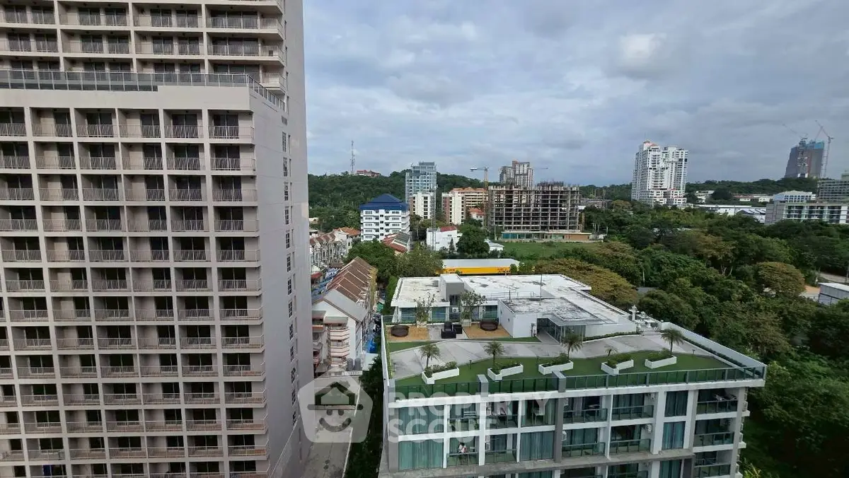 Stunning cityscape view from high-rise apartment with lush greenery and modern architecture.