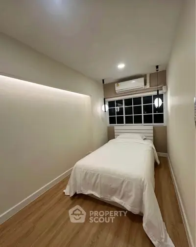 Cozy bedroom with modern lighting and wooden flooring