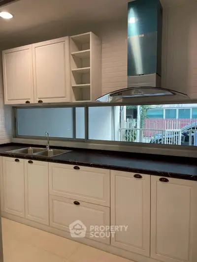 Modern kitchen with sleek cabinetry and stainless steel range hood