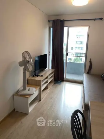 Cozy living room with balcony access and modern furnishings in a bright apartment.