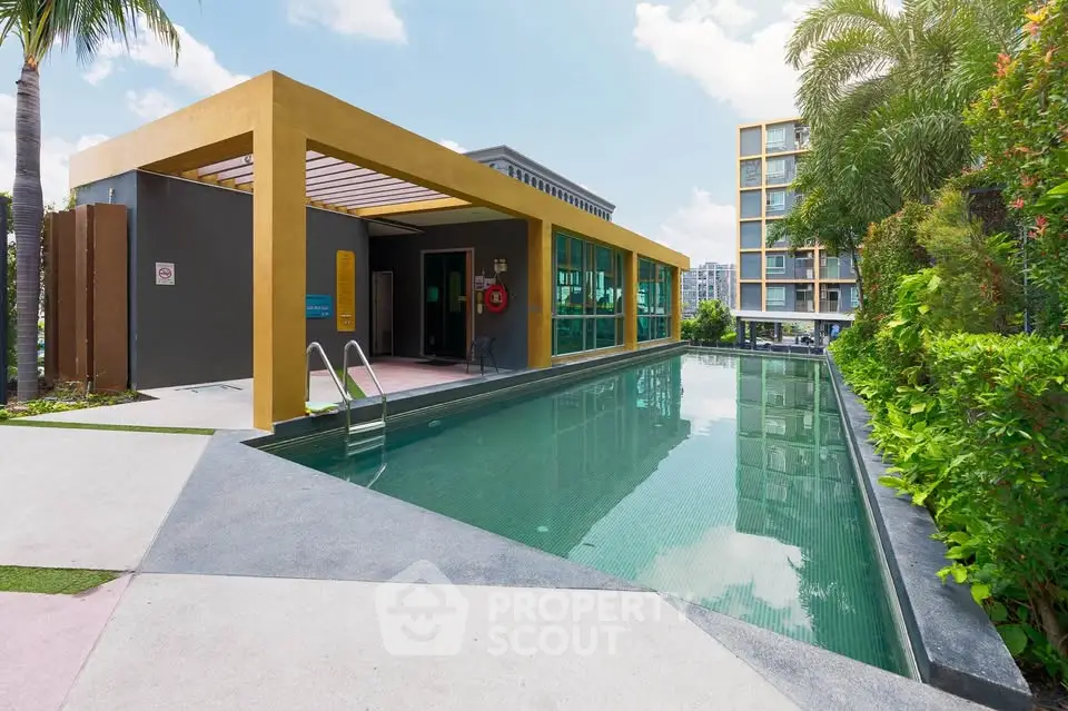Luxurious modern apartment complex with a sleek outdoor swimming pool and lush greenery.