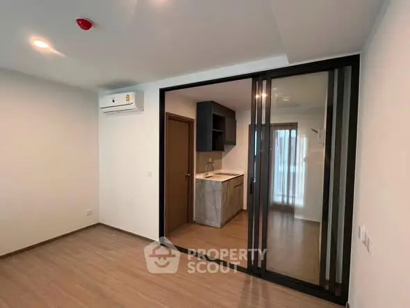 Modern apartment interior with sliding glass doors and air conditioning unit.