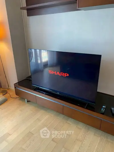 Modern living room with sleek TV setup on wooden stand, perfect for entertainment enthusiasts.