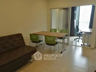 Modern living room with study area and balcony access in urban apartment.