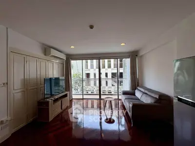 Spacious living room with modern furniture and large windows offering natural light and city views.