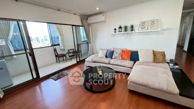 Spacious living room with modern decor and city view balcony in urban apartment.