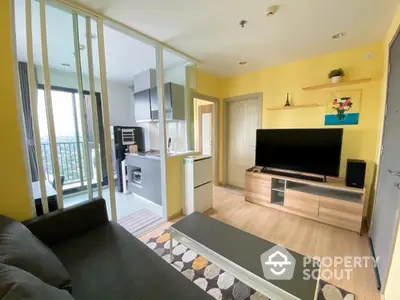 Modern living room with open kitchen and balcony view in bright apartment.