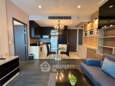 Modern living room with open kitchen, elegant chandelier, and stylish decor