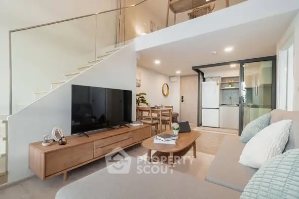 Modern open-plan living room with stylish furniture and kitchen in a bright duplex apartment.