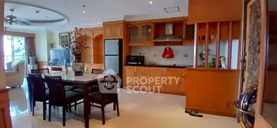 Spacious open-layout kitchen and dining area with modern appliances and elegant wooden cabinetry.