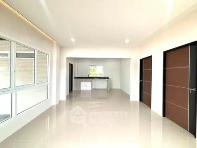 Spacious modern living room with sleek tile flooring and large windows for natural light.