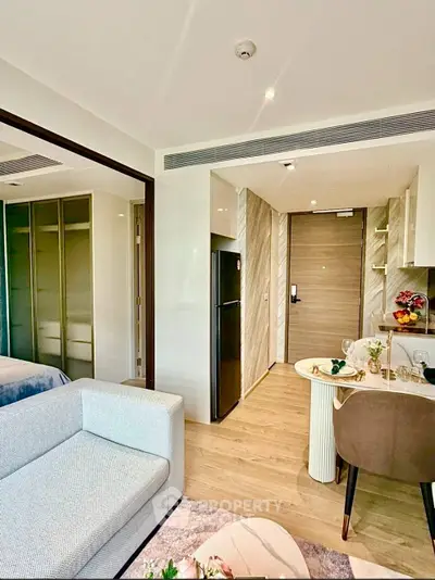 Modern apartment interior with open layout, featuring a cozy living area, sleek kitchen, and stylish dining space.