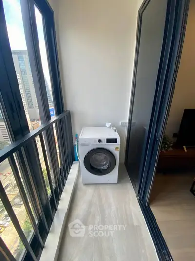 Compact balcony with washing machine and city view, perfect for urban living convenience.