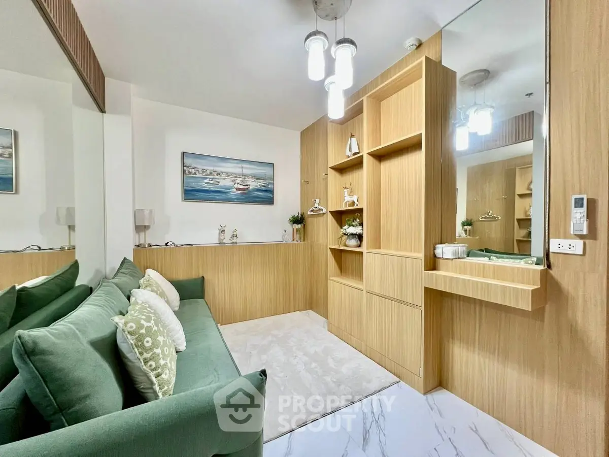 Stylish living room with green sofa, modern lighting, and wooden cabinetry for a cozy ambiance.