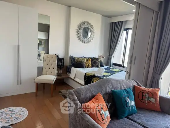 Stylish bedroom with modern decor and cozy seating area, perfect for relaxation.