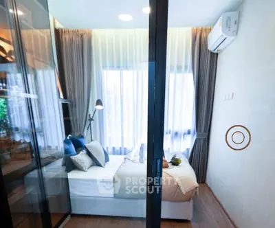 Modern bedroom with glass partition and stylish decor in a cozy apartment.