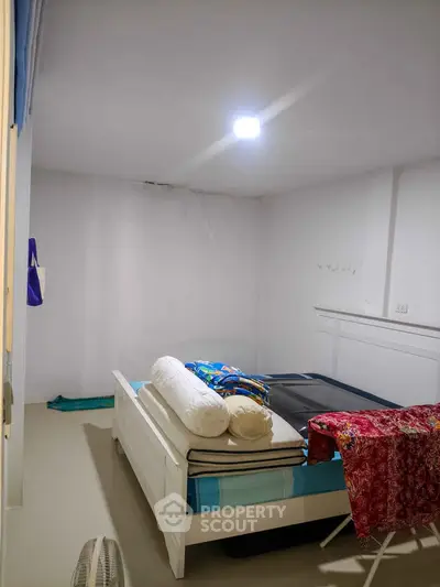 Cozy bedroom with simple decor and natural lighting, perfect for a peaceful retreat.