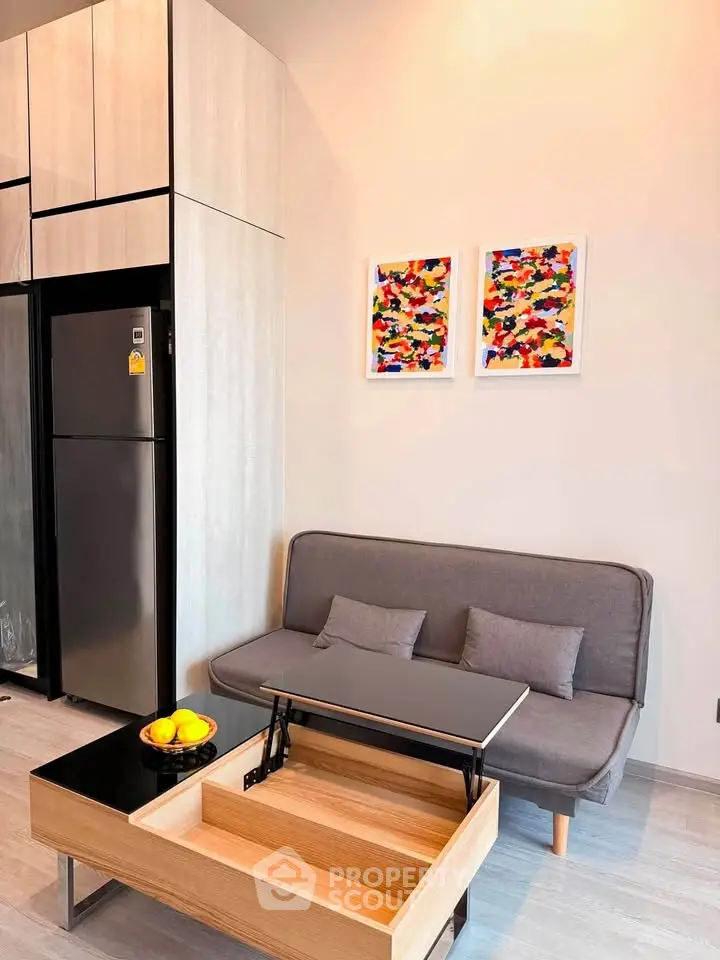 Modern living room with sleek furniture and vibrant artwork, featuring a compact sofa and multifunctional coffee table.