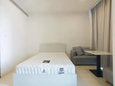 Modern minimalist bedroom with cozy sofa and natural light