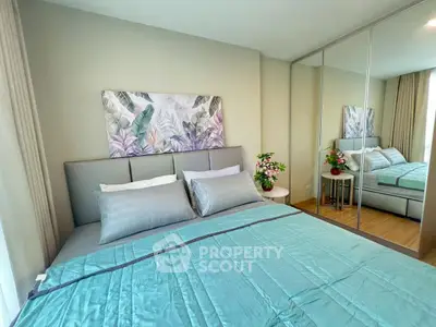 Modern bedroom with stylish decor and mirrored wardrobe in a cozy apartment.