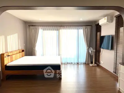 Spacious bedroom with modern decor and natural light