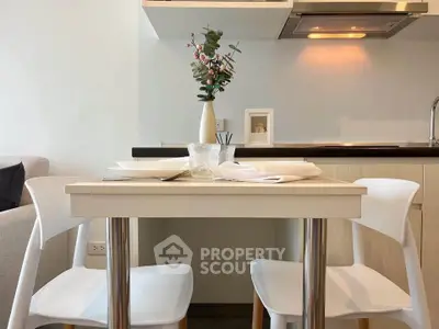 Modern kitchen with dining table and chairs, sleek design and cozy ambiance.